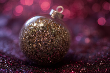 Sparkling gold bauble reflects festive light in a glittery winter setting
