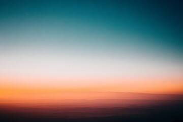 Fototapeta premium Stunning Gradient Sky at Sunset with Muted Landscape Silhouette
