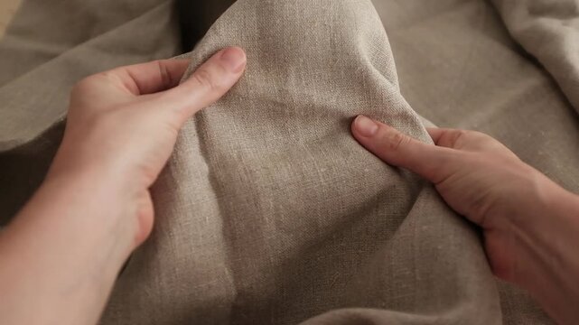 Closeup video of hands touching rough linen fabric. Appreciating texture of natural textile for clothes. Natural organic textile.