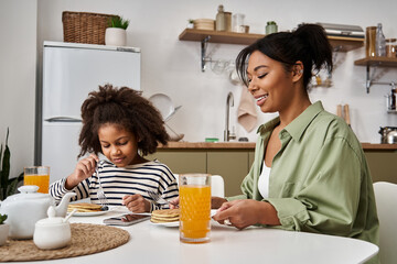 Enjoying a cheerful breakfast together at home, mother and daughter bonding moments