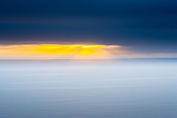 Fototapeta premium Dramatic sunrise sky over calm ocean waters for tranquil mood