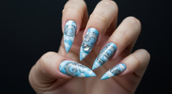 Hand adorned with fantastical stiletto nail art, showcasing detailed silver patterns, soft blue hues, and elegant sparkle