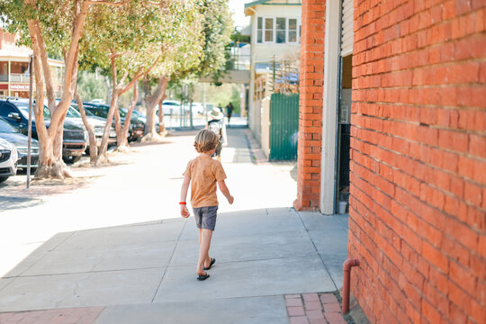 Child walking along quiet footpath on sunny day