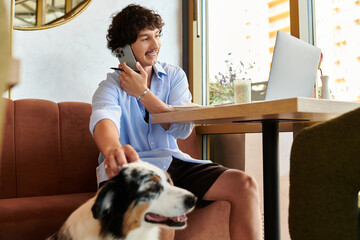 Handsome young man enjoying a productive moment at the cafe with a loyal companion nearby