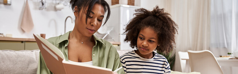 Fototapeta premium Heartwarming moments shared between mother and daughter at home enjoying a story