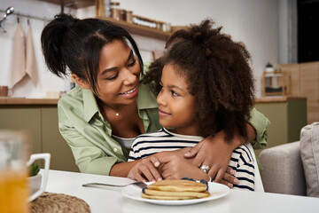 Embracing moments of love and laughter between a mother and her daughter at home