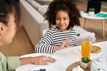 Joyful moments shared between mother and daughter during a cozy breakfast at home