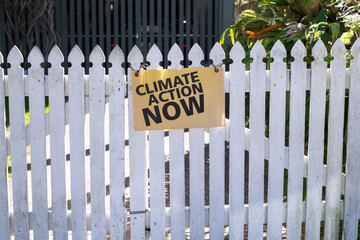 activist sign on fence, climate action now