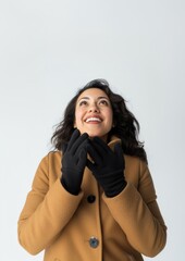 Fototapeta premium A joyful hispanic woman in her 30s in winter gloves smiling looking.