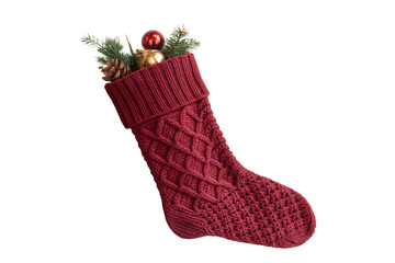 A cozy knitted red christmas stocking filled with festive greenery and ornaments isolated on transparent background