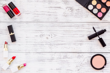 Flatlay of makeup cosmetics on wooden table. Blusher, mascara and lipstick, top view