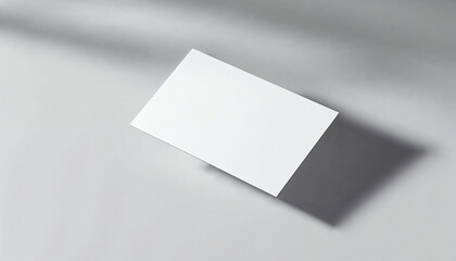 Minimal mockup of a white business card floating on a gray background with subtle shadows