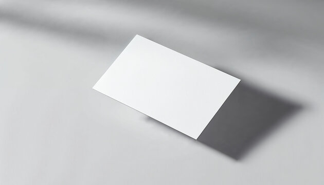 Minimal mockup of a white business card floating on a gray background with subtle shadows