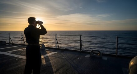 Sailor scans the horizon at sunset from a ship's deck, using binoculars.