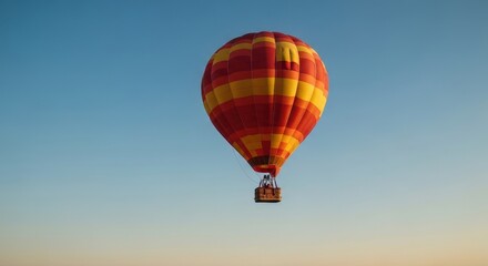 Naklejka premium Colorful Hot Air Balloon Flying Against Clear Blue Sky at Sunrise over Landscape