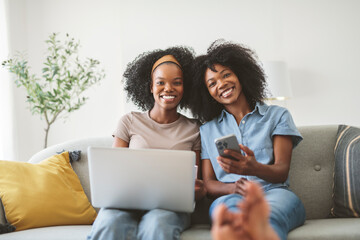 Fototapeta premium black mother and daughter using cellphone and laptop on sofa