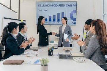 Group of Asian business people working together as a team to plan company strategy in brainstorming meeting at office. Casual business with startup teamwork concept, handshake concept.