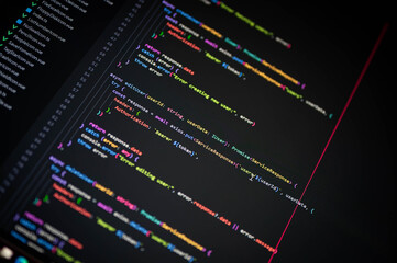 Close-up of programming source code with colorful syntax highlighting on a dark screen, illustrating software engineering, user management system, and web development in a modern IT workspace.