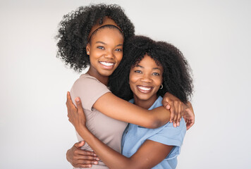 Affectionate mother and daughter portrait close to a white wall
