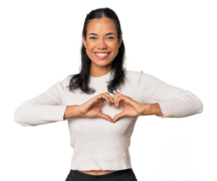 Young Filipina woman smiling and showing a heart shape with hands.