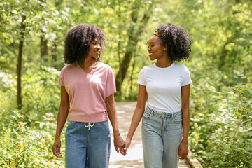 Fototapeta premium Black American mother and her daughter in forest.