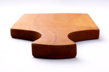 A simple, light brown wooden cutting board with a handle, isolated on a clean, white background. The smooth surface of the board is prominent