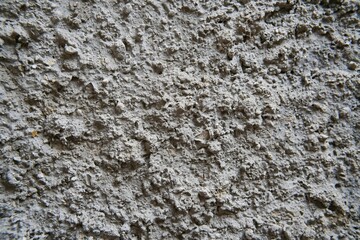 Close-up of a rough-textured cement surface. Rough cement plaster for the background.