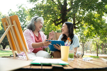 A senior mother and her daughter spend quality time together outdoors, sharing a tender moment filled with love and care. Their strong family bond reflects warmth and togetherness in every embrace