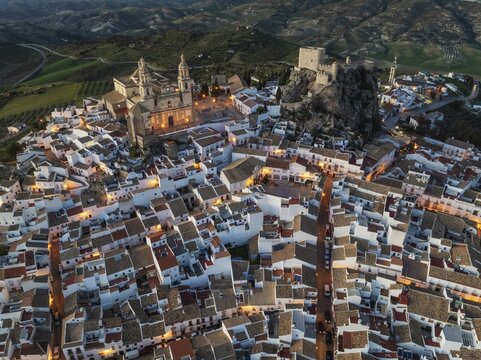 The hilltop White Town of Olvera with its La Encarnaci&oacute;n church and Moorish castle. At dusk. Aerial view. Drone shot. C&aacute;diz province, Andalusia, Spain