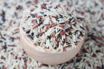 Close up of brown rice on a wooden bowl on background. Healthy food.