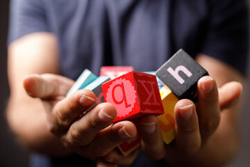 Close-up of child's hands gently holding colorful alphabet blocks. Perfect for education, learning, childhood, and literacy concepts.