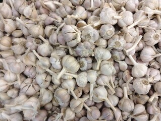 piles of garlic in supermarket display baskets, a bunch of garlic sold in stores, fresh garlic in store baskets