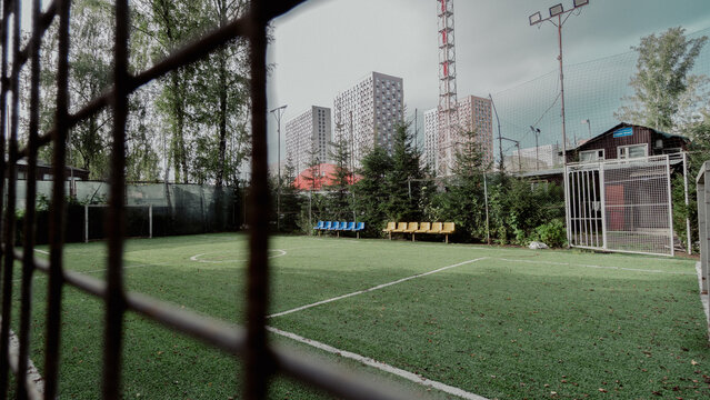 fenced soccer field with urban backdrop