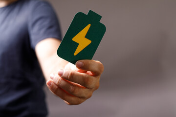 High-quality image of a hand holding a green battery symbol, perfect for energy, power, and...
