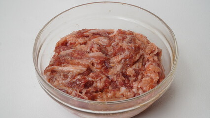 raw marinated beef slice on glass bowl isolated on white background