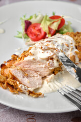 Delicious almond-crusted chicken breast served with fresh salad.