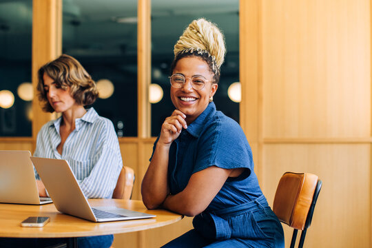 Professional women working and smiling in a modern office setting - Powered by Adobe