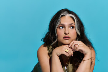 Stylish woman with Waardenburg syndrome exudes confidence against vibrant blue backdrop