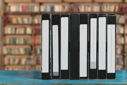 Vintage VHS videotape collection with blank labels in library background