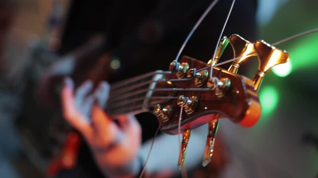 A man plays guitar on a music stage, close-up