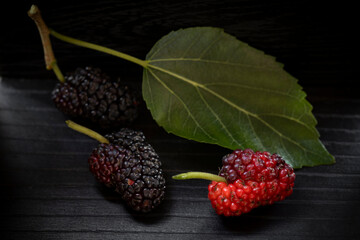 Fresh Ripe Mulberry with Leaf on Dark Wooden Background