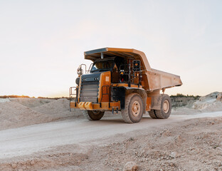 Large Haul Truck Carrying Minerals in Open Pit Mine at Sunset