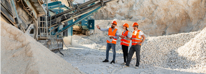 Engineers inspecting rock crushing machine in quarry