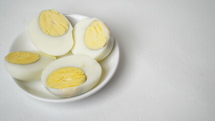 Peeled boiled eggs served on a white plate with a white background
