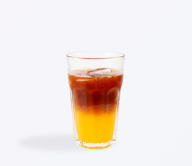 Refreshing iced americano coffee layered with bright orange juice, served in a tall clear glass with ice cubes and condensation for a summer vibe