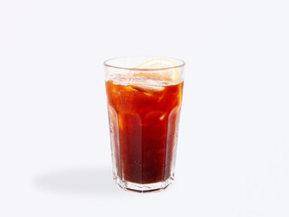 Chilled iced americano coffee with a fresh lemon slice, served in a clear glass with ice cubes and condensation, isolated on a light background