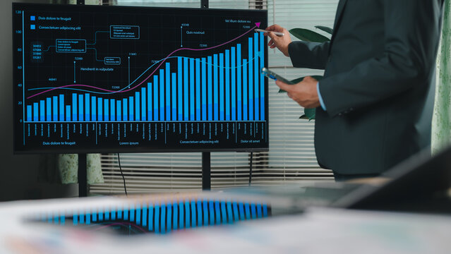 Executive analyzing digital business data screen. Hand points dynamic growth chart. Financial projections, market trends, corporate analytics drive strategic decisions. Professional success, economic