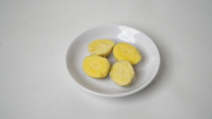 Peeled boiled eggs served on a white plate with a white background