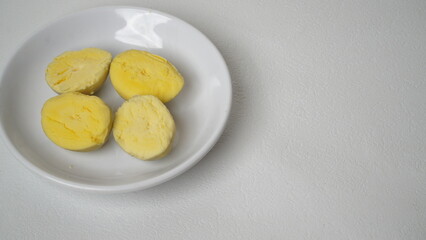 Peeled boiled eggs served on a white plate with a white background