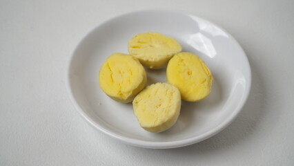 Peeled boiled eggs served on a white plate with a white background